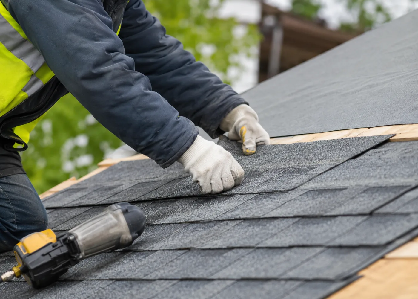 Roof Replacement in New Berlin - WI underway as a crew removes worn shingles from a suburban home, Roof replacement crew in Waukesha - WI securing flashing and shingles along a steep residential roofline